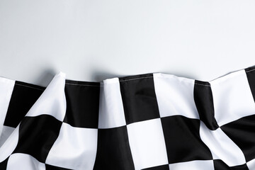 Checkered finish flag on white background, top view. Space for text