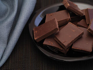Broken dark chocolate in a black plate