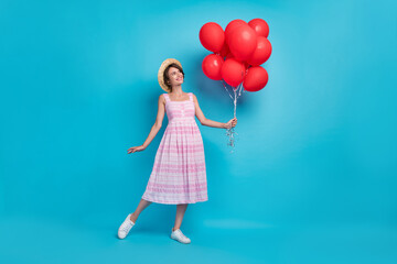 Obraz na płótnie Canvas Full length photo of birthday millennial lady hold balloons wear hat long sarafan shoes isolated on blue background