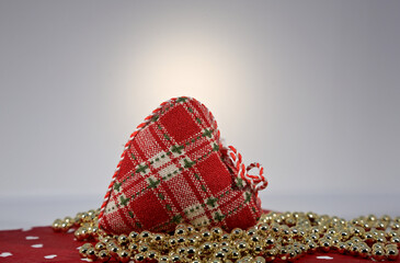 A red textile heart with  golden bauble pearls