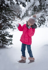 Fototapeta na wymiar Child in winter. A little girl, playing in the winter outside.