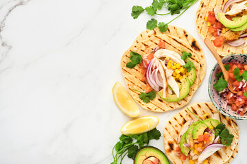 Mexican tacos with grilled chicken, avocado, corn kernels, tomato, onion, cilantro and salsa at...