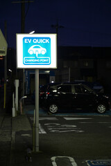 EV Quick charging point for electric vehicles sign. Blue light up sign.