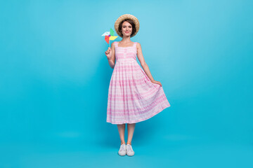 Full length photo of cute millennial carefree lady hold toy wear hat pink long sarafan isolated on blue color background