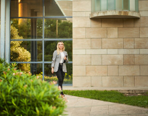 young businesswoman walking out of office with agenda in hand