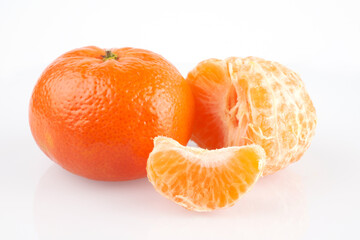 Ripe juicy orange tangerine whole in peel and slices isolated on white background with copy space, flat lay clipping path