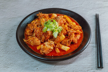 Korean food Spicy Stir-fried Chicken tteokbokki dish on black plate