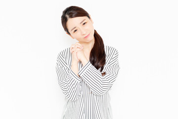 お願いのポーズをするカジュアルな服装の女性