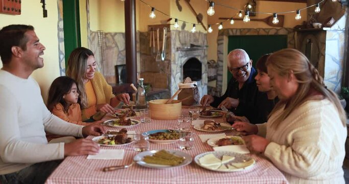 Happy latin family eating lunch together at home on patio