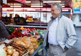 Middle aged man buying vegetables