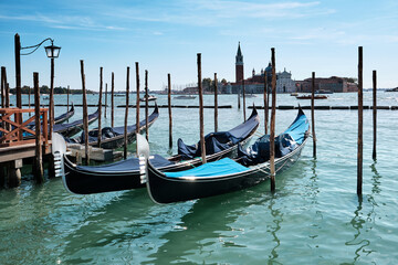 Fototapeta na wymiar Gondolas moored by Saint Mark square with San Giorgio di Maggiore church in the background. Venice, Venezia, Italy, Europe.