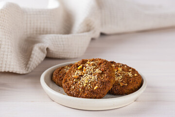 Carrot cookies with oatmeal, quinoa and almonds on a light plate. Sugar, gluten and lactose free and vegan.
