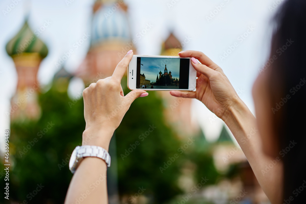 Aufkleber back view of unrecognizable female tourist using cellphone camera for photographing architecture in 