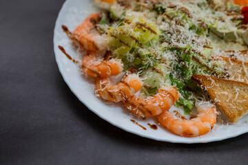 Caesar salad dish with shrimp lettuce and cherry tomatoes