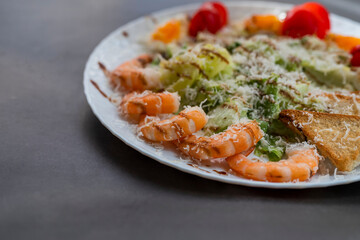 Caesar salad dish with shrimp lettuce and cherry tomatoes
