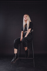 Fototapeta na wymiar blonde girl in the studio on a black background in black clothes