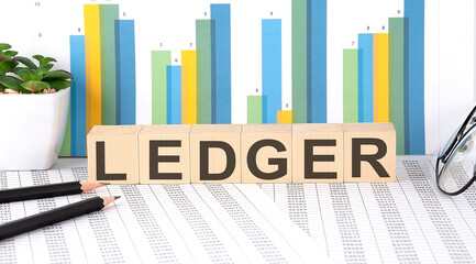LEDGER word written on wood block with chart, glasses and pencils