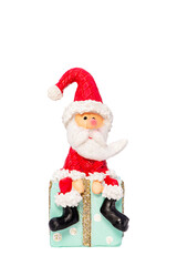 Sitzender Weihnachtsmann auf einem Weihnachtspackerl vor einem weißen Hintergrund