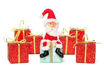 Sitzender Weihnachtsmann, mit sieben Weihnachtspackerl vor einem weißen Hintergrund