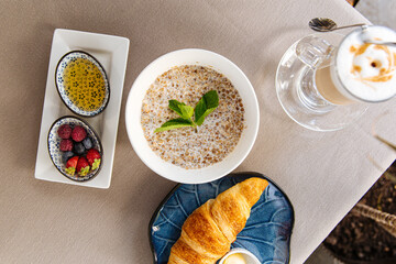 Served breakfast with porridge and croissant on restaurant table