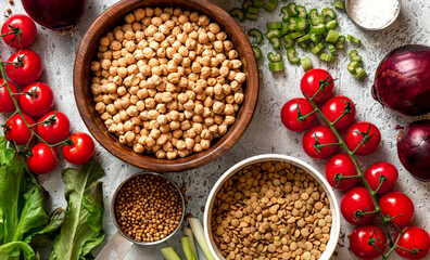 Various vegetables, spices and chickpeas on a gray concrete background top view. Vegan food, healthy eating concept. Food background. Cooking food.