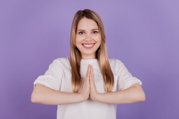 Fototapeta premium Photo of cheerful positive lady hold hands together plead gesture wear casual t-shirt on violet background