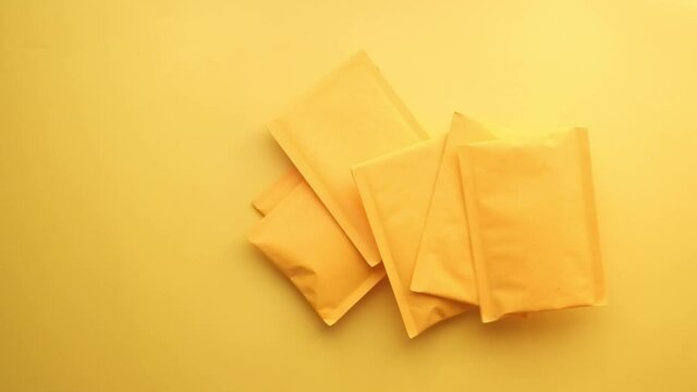 dropping yellow paper bubble envelope on table 