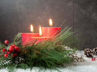Red Christmas candle and Christmas decorations on a gray background.