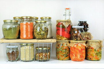 Variety of vegetarian products and fermented foods in glass jars for storage on white wooden table. Healthy vegan cooking, clean eating, zero waste concept. Balanced dieting food.