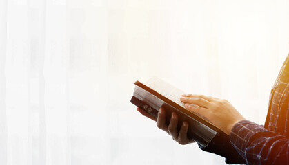 read the bible Close-up of a woman's hand reading the Bible by the window white background