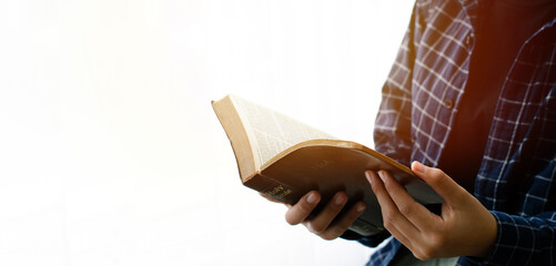 read the bible Close-up of a woman's hand reading the Bible by the window white background