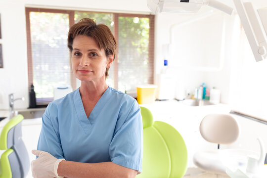 Portrait of smiling caucasian female dental nurse looking at camera at modern dental clinic