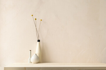 Design vases with dry flowers on a table against beige stucco wall in the bathroom. Mockup.	
