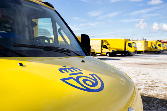 Santiago de Compostela, Spain. November 7, 2021: Correos logo of a Van and correos delivery trucks parked at background