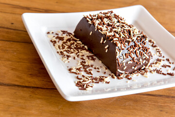 Chocolate pudding with sprinkles, delicious chocolate dessert on wooden table