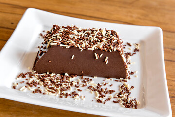 Chocolate pudding with sprinkles, delicious chocolate dessert on wooden table
