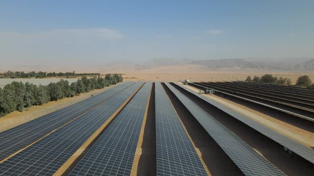 Drone Aerial footage of small solar energy system farm with many modules or panels rows along the dry lands In Israel desert . Low attitude solar panels above free energy and renewable energy