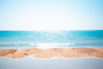 Defocused landscape.Beautiful sparkling sea with a strip of sandy shore, blurred focus. Natural...