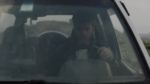 Ragazzo con auto in panne in campagna