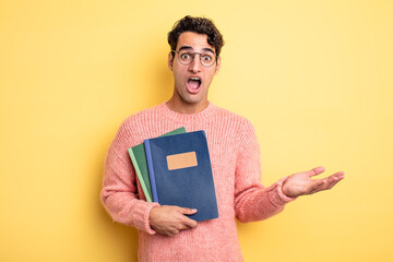 young handsome man amazed, shocked and astonished with an unbelievable surprise. notebook concept