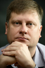 Fototapeta premium Portrait of beautiful adult light blue-eyed man in a shirt on a gray background.
