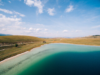 Fototapeta na wymiar Clear water of Lake Vrazje against the blue sky. Montenegro