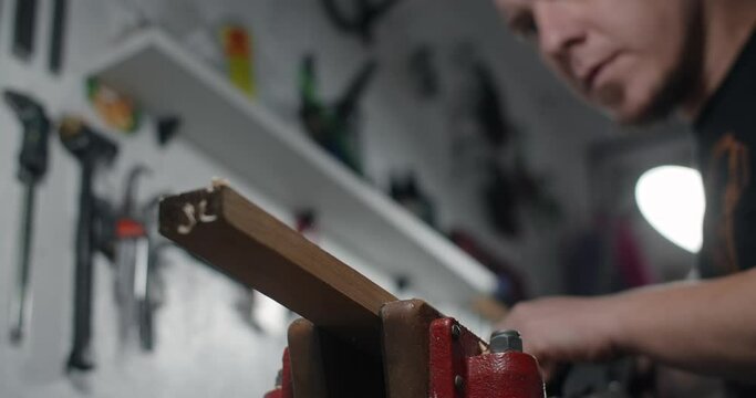 Carpenter uses hand plane for wood processing at his workshop. Guitar maker uses jack plane in slow motion, 4k 60p Prores HQ