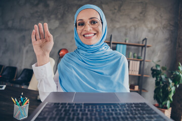 Photo of teacher millennial arabian attractive lady talk laptop wear spectacles hijab shirt indoors workplace