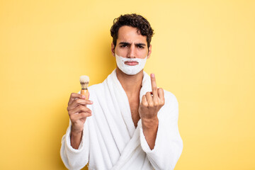 young handsome man feeling angry, annoyed, rebellious and aggressive. shaving and foam concept