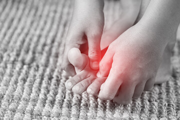 A woman suffering from feeling knee pain sitting sofa at home. hand massaging her painful knee. Health care and medical concept.