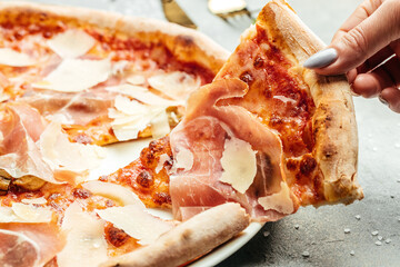 Cured parma ham on a Traditional Italian pizza with parmesan cheese and tomato on a thick pastry...