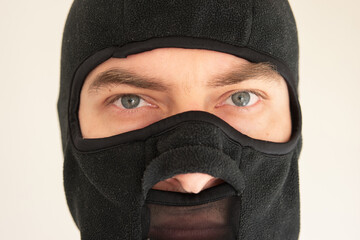 Caucasian male face wearing a black fabric ski mask. Close up shot, unrecognizable