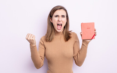 young pretty woman shouting aggressively with an angry expression. agenda concept