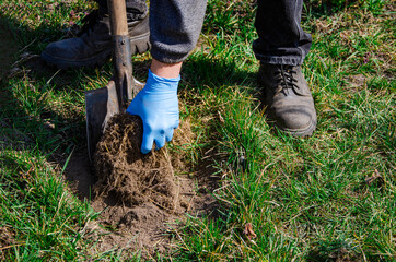 Close-up, shallow DOF. Digging spring soil with shovel
